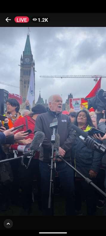 With the Peace Tower in the background, PSAC National President Chris Aylward speaks to media during a rally on Parliament Hill, April 26, 2023. Image courtesy PSAC National/Facebook.