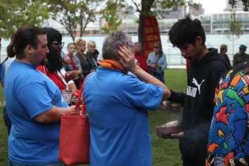 Attendees at a vigil for murdered and missing indigenous women receive a blessing at Dieppe Gardens in Windsor, October 4, 2017. Photo by Mark Brown/Blackburn News.