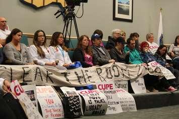 Striking library workers in Essex County with CUPE Local 2974 attend the regular meeting of Essex County Council on November 2, 2016. holding a banner that reads "clear the room 2018." (Photo by Ricardo Veneza)