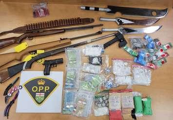 An assortment of seized weapons, drugs, and other items is displayed in Leamington on August 8, 2022. Photo submitted by Ontario Provincial Police.