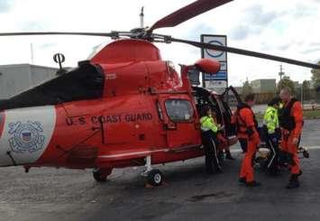 A Coast Guard air crew,  transports a man to waiting paramedics at the Windsor Airport on October 27, 2013. (Photo courtesy of the US Coast Guard)