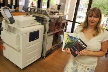 Windsor Public Library self-publishing facilitator Sue Perry stands beside the machine where anyone can become an author, July 23, 2015. (Photo by Jason Viau)