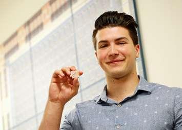Second-year electrical and computer engineering student Austin Liolli with the lab-on-a-chip, October 31, 2016. (Photo courtesy University of Windsor)