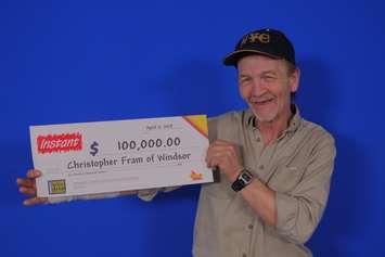 Christopher Fram of Windsor shows off the $100,000 cheque for playing the OLG's Instant Power 5s at the OLG Prize Centre in Toronto, April 15, 2019. Photo provided by OLG.