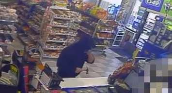 A man is seen robbing a convienence store with a claw hammer on Lauzon Rd. in Windsor, August 25, 2016. (Photo courtesy of the Windsor Police Service via YouTube)