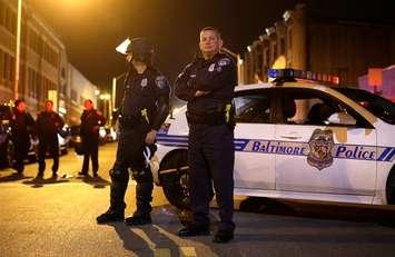 Members of the Baltimore Police Department wait for curfew to begin for the third night, Thursday, April 30, 2015, in Baltimore. (AP Photo/Patrick Semansky)